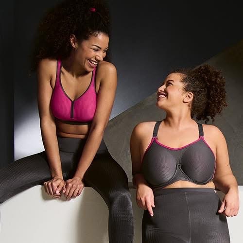 Two women wearing premium sports bras smiling together